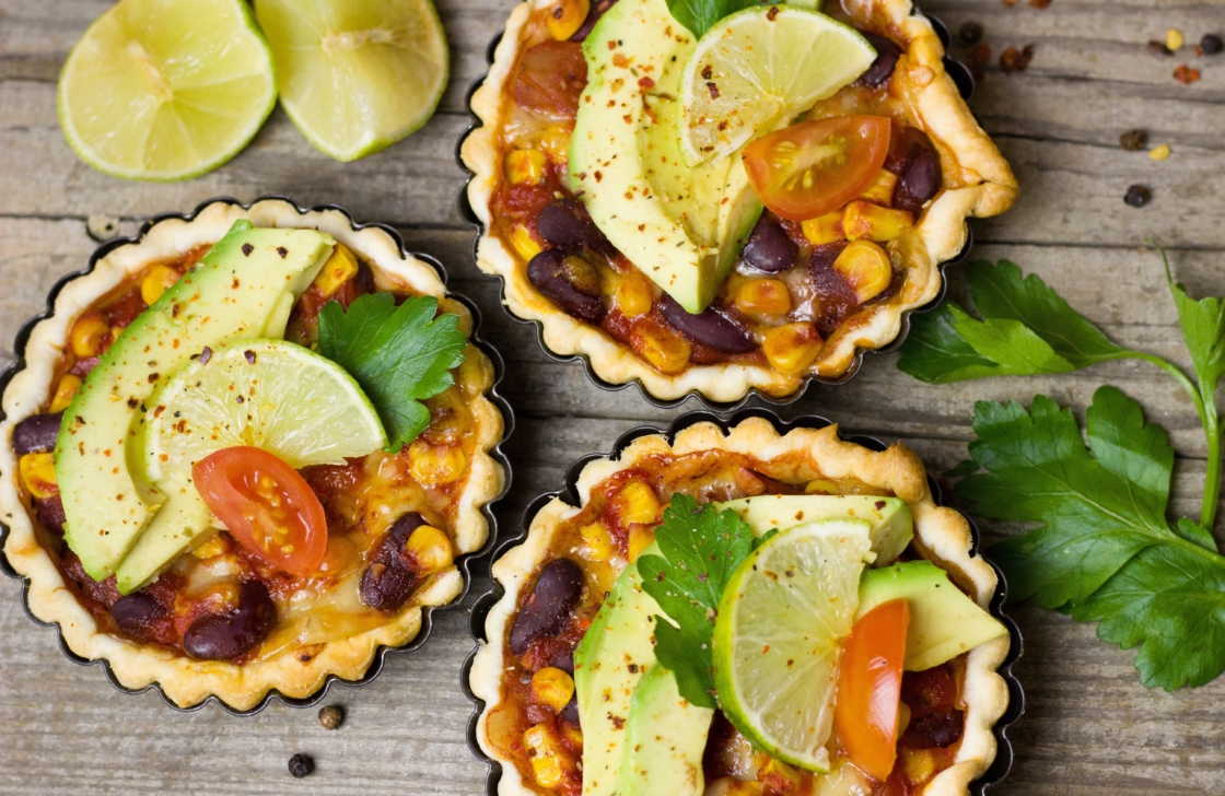 Three Mexican dishes on a wooden table.